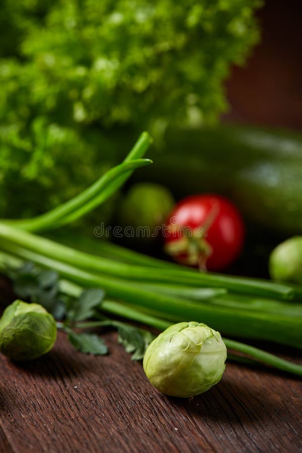 Vegetarian still life of fresh vegetables on wooden plate over rustic background, close-up, flat lay. royalty free stock images Vegetarian still life of fresh vegetables on wooden plate over rustic background, close-up, flat lay. royalty free stock images