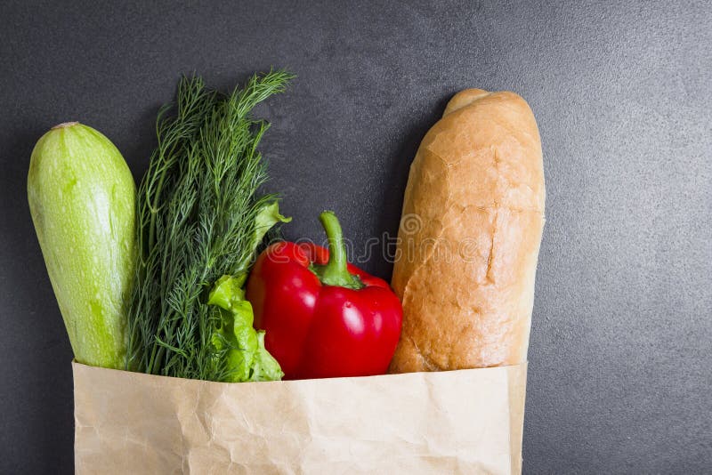 Vegetarische aankopen bij kruidenierswinkelopslag Groenten in document zak op zwarte achtergrond Gezond voedselconcept Pak met gr stock foto Vegetarische aankopen bij kruidenierswinkelopslag Groenten in document zak op zwarte achtergrond Gezond voedselconcept Pak met gr stock foto
