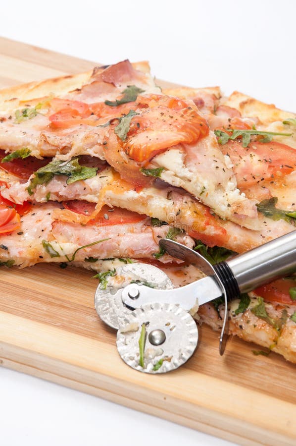 VEGETARISCHE RUCOLA TOMATEN-PIZZA DES TRENNMESSER- stockfotografie VEGETARISCHE RUCOLA TOMATEN-PIZZA DES TRENNMESSER- stockfotografie