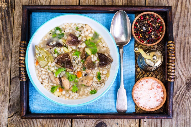 Vegetarische soep met paddestoelen en parelgort voor lunch op houten lijst royalty-vrije stock afbeelding Vegetarische soep met paddestoelen en parelgort voor lunch op houten lijst royalty-vrije stock afbeelding