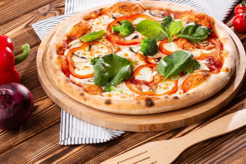 Vegetarisk pizza på en träbakgrund med champinjoner, broccoli, ost och söt peppar och basilika Top besk?dar arkivfoton Vegetarisk pizza på en träbakgrund med champinjoner, broccoli, ost och söt peppar och basilika Top besk?dar arkivfoton