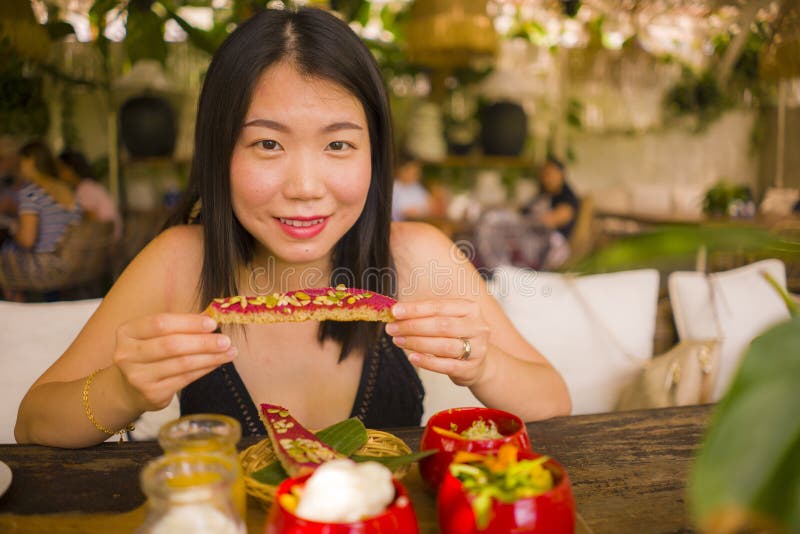 Veggie brunch . natural lifestyle portrait of young happy and beautiful Asian Chinese woman eating outdoors having organic stock images Veggie brunch . natural lifestyle portrait of young happy and beautiful Asian Chinese woman eating outdoors having organic stock images