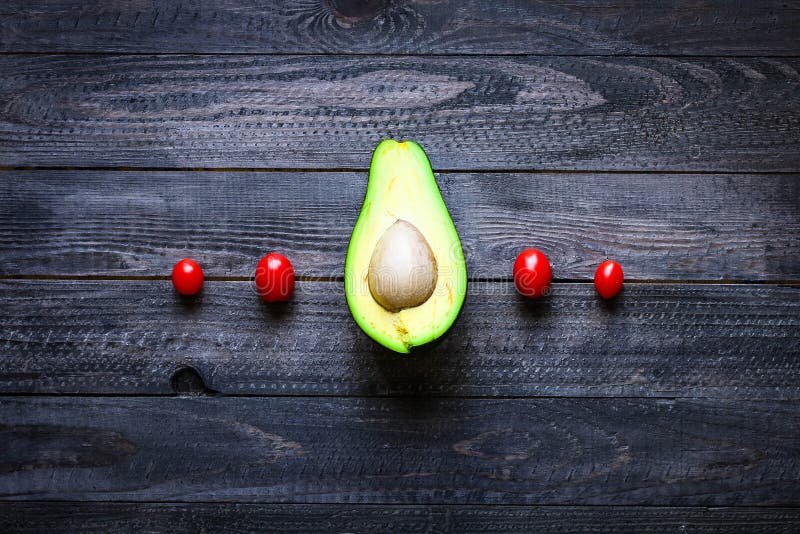 Veggie Food composition with half avocado over a darkdish stock photography