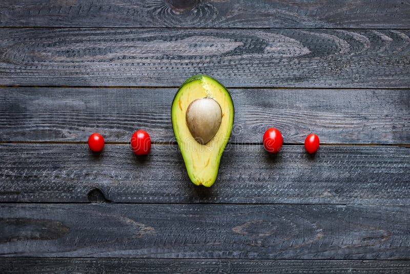 Veggie Food composition with half avocado over a darkdish royalty free stock photography