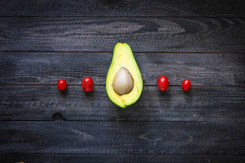 Veggie Food composition with half avocado over a darkdish stock photography