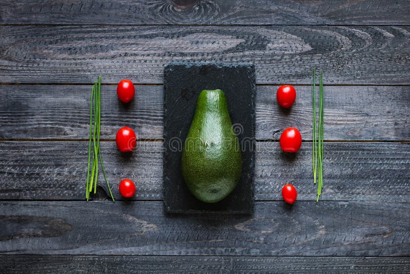 Veggie Food composition with half avocado over a darkdish royalty free stock images
