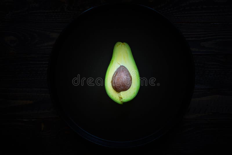 Veggie Food composition with half avocado over a darkdish stock images