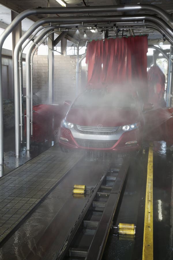Vehicle on Conveyor Belt Moving through Car Wash Process Stock Photo