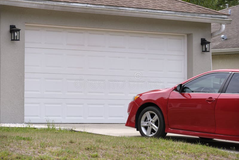 Vehicle Parked In Front Of Wide Garage Double Door On Paved Driveway Of