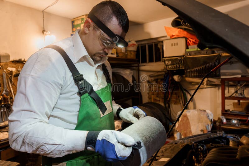 Vehicul mecanic de control și reparare a mașinilor în atelierul de service Wellequipped royalty free stock images
