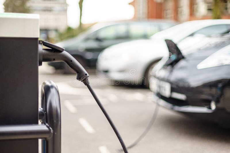 Vehículo eléctrico que carga en la calle, en Reino Unido imágenes de archivo libres de regalías Vehículo eléctrico que carga en la calle, en Reino Unido imágenes de archivo libres de regalías
