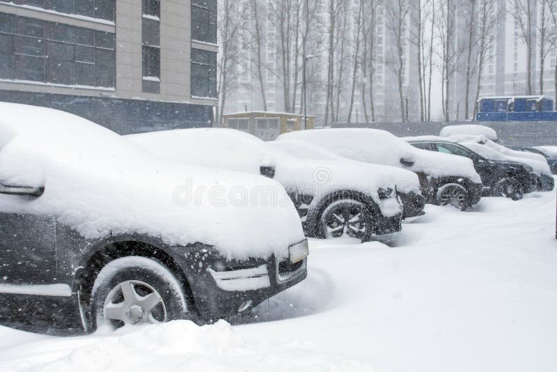 Vehículos cubiertos con nieve en la ventisca del invierno en el estacionamiento foto de archivo libre de regalías Vehículos cubiertos con nieve en la ventisca del invierno en el estacionamiento foto de archivo libre de regalías