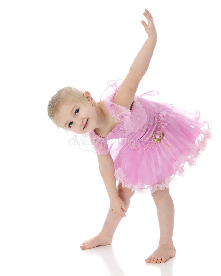 An adorable preschooler making up a dance move while in her ballet costume. On a white background. An adorable preschooler making up a dance move while in her ballet costume. On a white background.