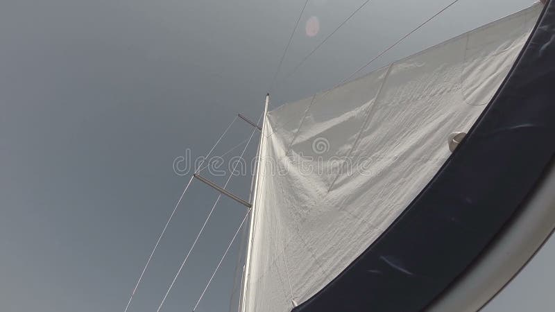 Vela blanca en viento contra el cielo, tiro del ángulo bajo, navegando almacen de video