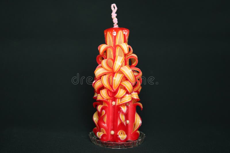 Vela tallada a mano hecha de capas rojas y fotos de archivo