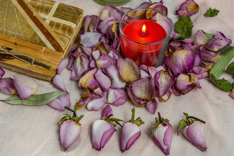 Velas e livro de rosas secas imagens de stock