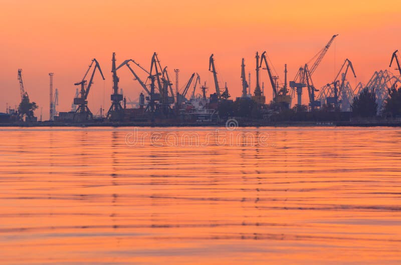 Vele kranen silhouetteren in de haven bij licht van zonsondergang stock afbeelding Vele kranen silhouetteren in de haven bij licht van zonsondergang stock afbeelding