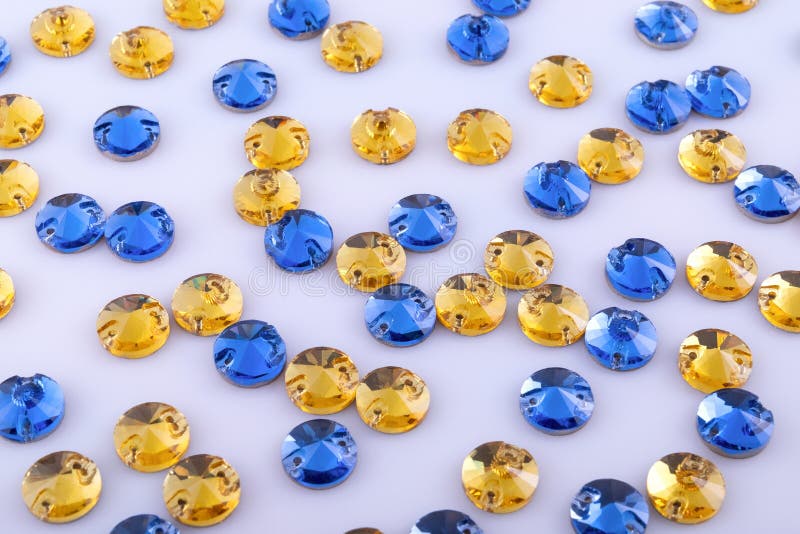 Many round yellow and blue sewn stones on a white background. Many round yellow and blue sewn stones on a white background.