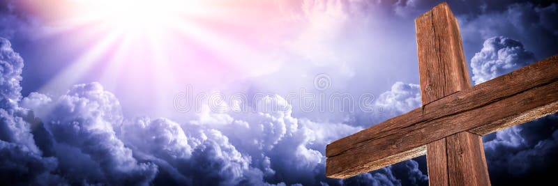A velha cruz robusta com nuvens e gloriosa luz do céu
