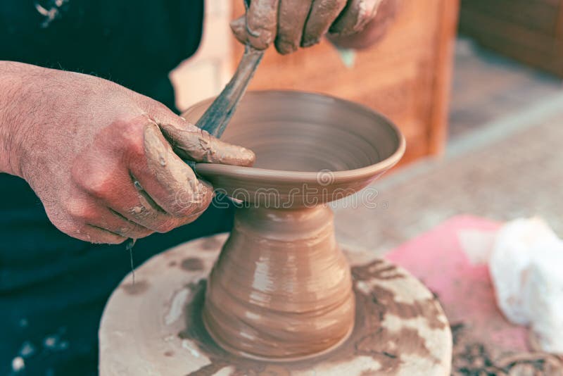 Mestre feminino trabalhando com argila crua na sala de cerâmica