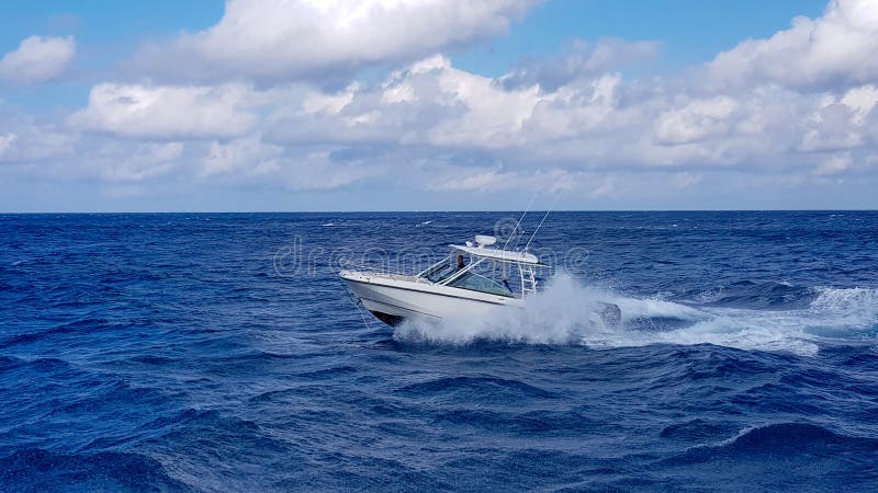 Velocidade que pesca o barco macio que salta as ondas no mar e que cruza o dia azul do oceano no Bahamas Água bonita azul