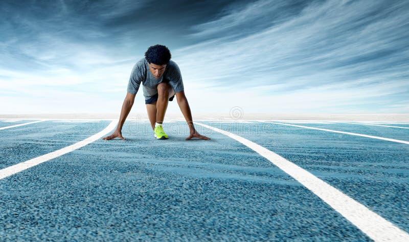 Velocista determinado novo que prepara-se para começar na pista de atletismo fotografia de stock royalty free Velocista determinado novo que prepara-se para começar na pista de atletismo fotografia de stock royalty free