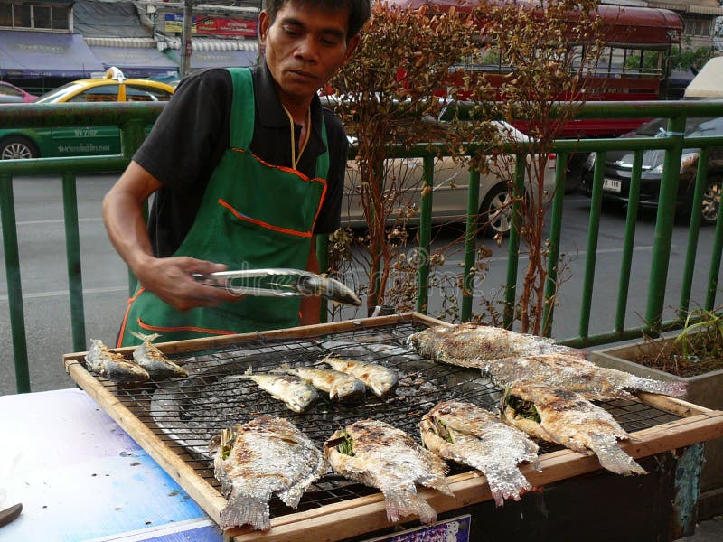Vendedor ambulante que cocina pescados en Bangkok Tailandia imagen de archivo Vendedor ambulante que cocina pescados en Bangkok Tailandia imagen de archivo