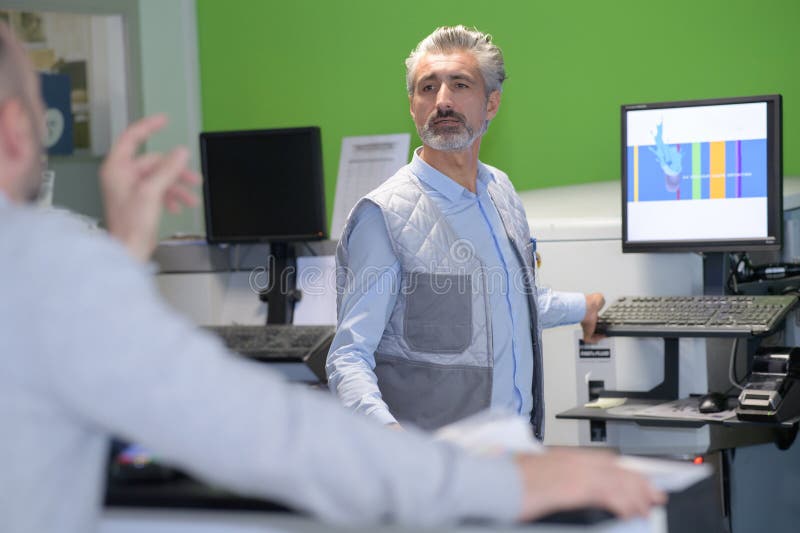 Assistente de vendas ajuda o comprador a escolher um portátil imagem de stock royalty free