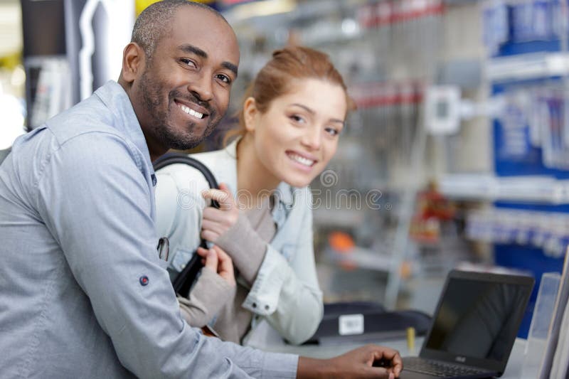 Assistente de vendas ajuda cliente numa loja de ferragens imagem de stock royalty free