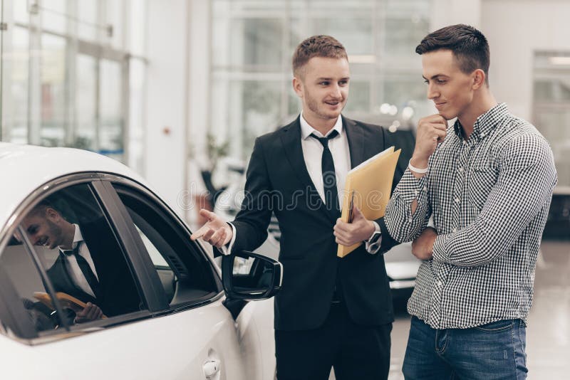 Vendedor de carro que trabalha com um cliente no negócio imagens de stock Vendedor de carro que trabalha com um cliente no negócio imagens de stock