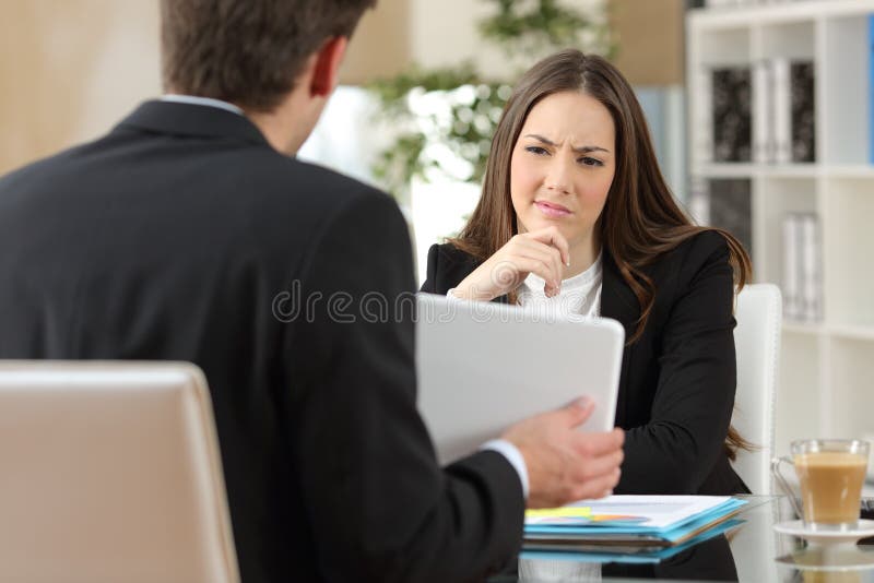 Vendeur essayant de convaincre un client douteux image libre de droits Vendeur essayant de convaincre un client douteux image libre de droits