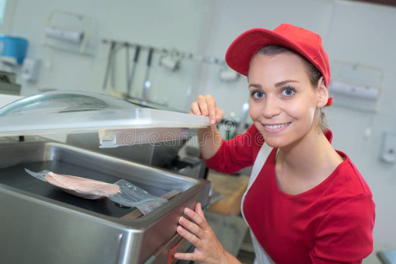 Vendeuse heureuse de portrait tenant des paquets de viande au compteur images libres de droits Vendeuse heureuse de portrait tenant des paquets de viande au compteur images libres de droits