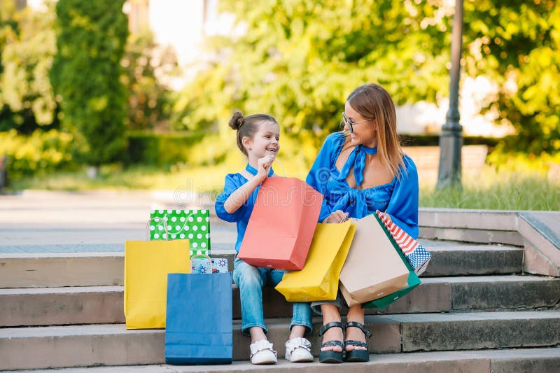 Vendita, consumismo e concetto di gente - giovani felici, sua figlia con borse della spesa per strada