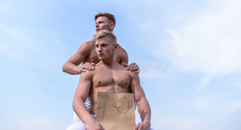 Hot sales and discount. Guys attractive twins carry shopping bag. Healthy lifestyle concept. Brothers buy eco healthy products. Sales season. Men muscular athletes hold shopping bag sky background. Hot sales and discount. Guys attractive twins carry shopping bag. Healthy lifestyle concept. Brothers buy eco healthy products. Sales season. Men muscular athletes hold shopping bag sky background.