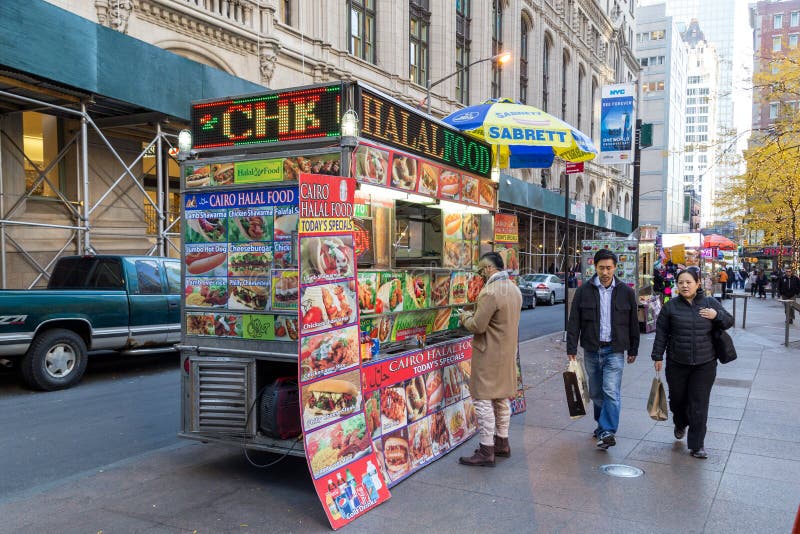 New York, United States of America - November 18, 2016: Customer at a street vendor cart in the streets of Lower Manhattan. New York, United States of America - November 18, 2016: Customer at a street vendor cart in the streets of Lower Manhattan