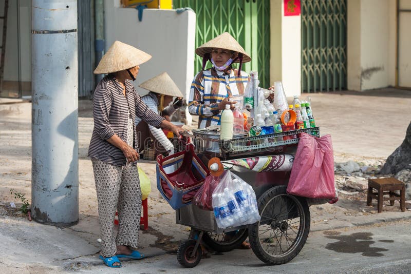 Ho Chi Minch City, Vietnam December 10, 2013. Unidentified Vietnamese street vendor communicates with other woman on December 10, 2013 in the street of Ho Chi Minh City. Ho Chi Minch City, Vietnam December 10, 2013. Unidentified Vietnamese street vendor communicates with other woman on December 10, 2013 in the street of Ho Chi Minh City.