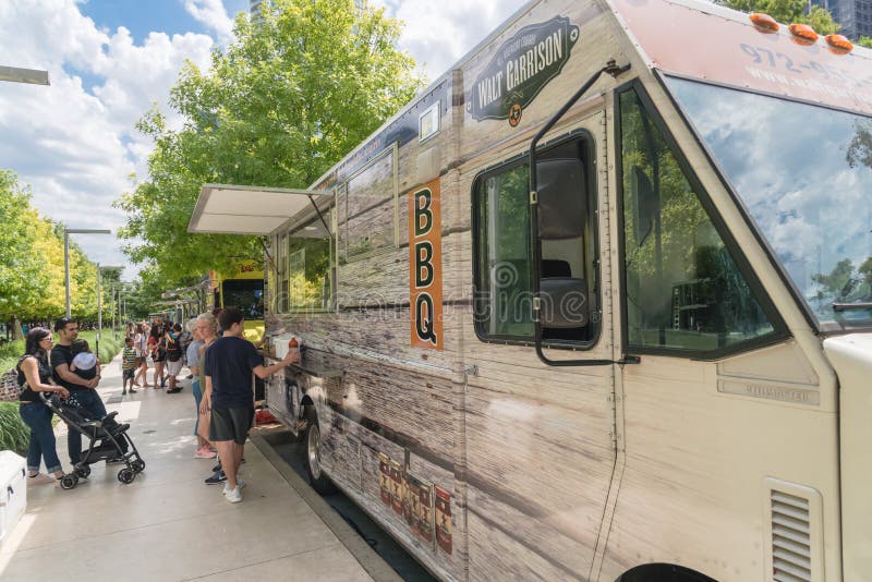 DALLAS, TX, USA-MAY 26, 2018:Food truck vendor with customer buy and taste variety of food at Klyde Park in Downtown Dallas. Waiter taking order from customer at counter of mobile kitchen street eat. DALLAS, TX, USA-MAY 26, 2018:Food truck vendor with customer buy and taste variety of food at Klyde Park in Downtown Dallas. Waiter taking order from customer at counter of mobile kitchen street eat