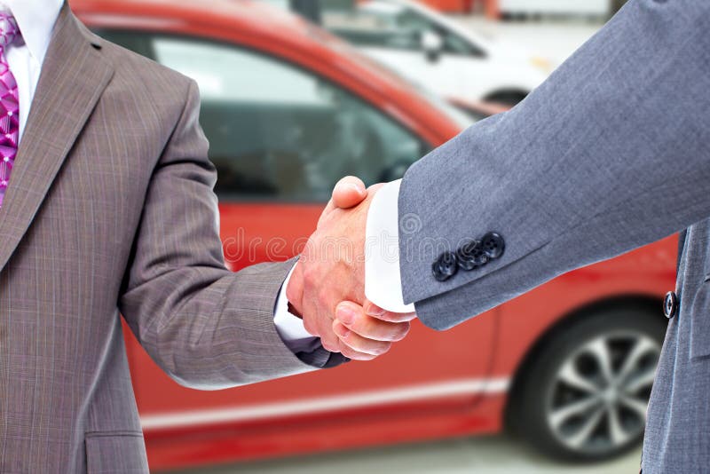Venditore dell'automobile e stretta di mano del cliente fotografie stock Venditore dell'automobile e stretta di mano del cliente fotografie stock