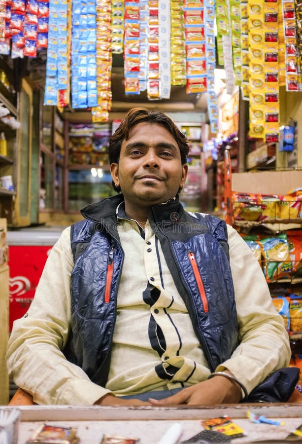 MUMBAI, INDIA - 05 FEBRUARY 2015: Portrait of Indian vendor sitting in shop with gutka hanging in background. MUMBAI, INDIA - 05 FEBRUARY 2015: Portrait of Indian vendor sitting in shop with gutka hanging in background.