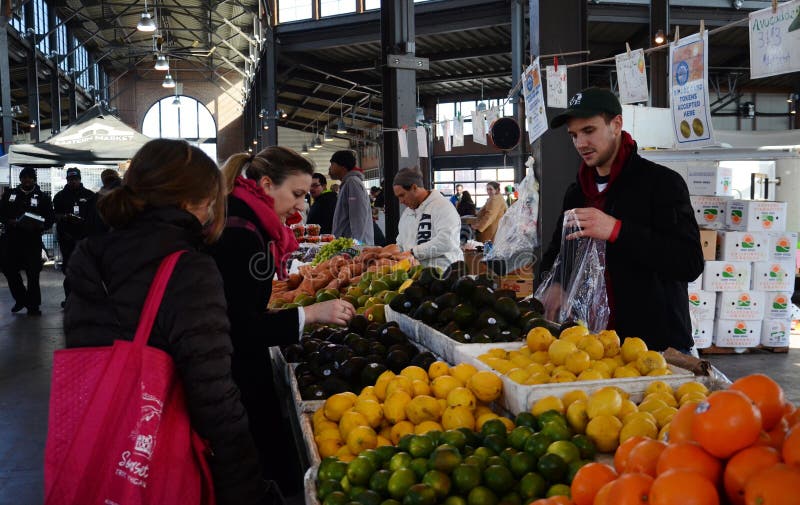 DETROIT, MI - FEBRUARY 6: A vendor bags produce for a customer at Eastern Market, the largest historic public market district in the United States, on February 6, 2016. DETROIT, MI - FEBRUARY 6: A vendor bags produce for a customer at Eastern Market, the largest historic public market district in the United States, on February 6, 2016.