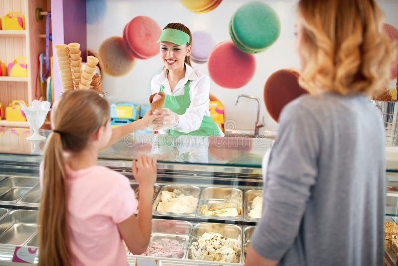 Vendor in confectionery serves young customer