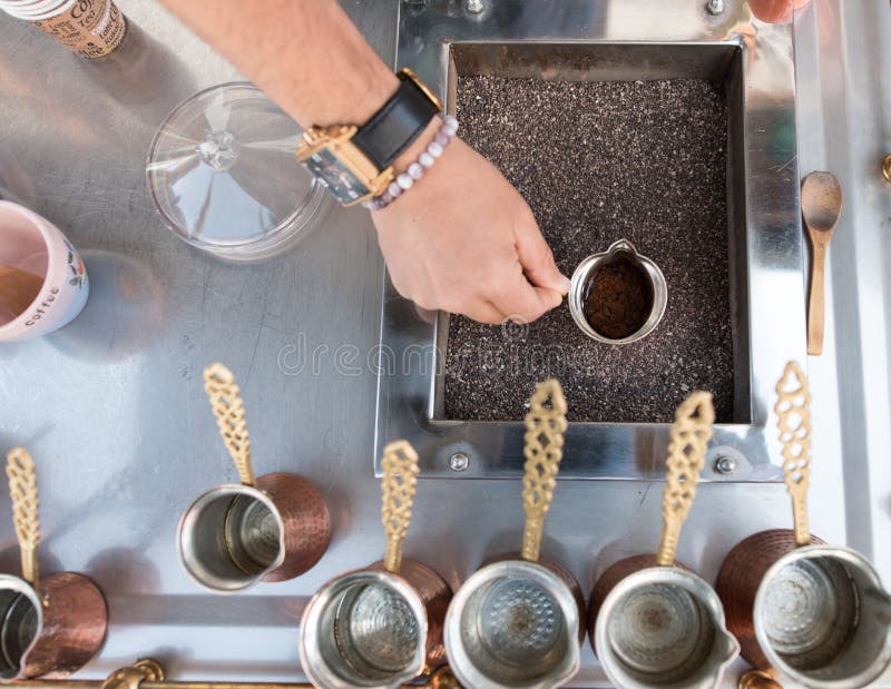 Vendor Prepares Turkish Coffee on the street. A street vendor is preparing Turkish coffee on the street of a town in Turkey. Turkish coffee is prepared using stock photo Vendor Prepares Turkish Coffee on the street. A street vendor is preparing Turkish coffee on the street of a town in Turkey. Turkish coffee is prepared using stock photo