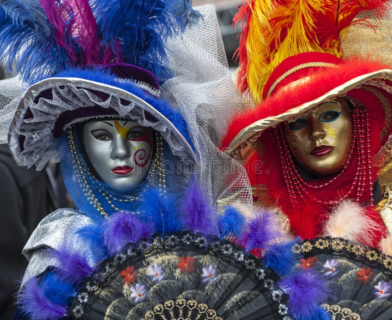 Venice, Italy- February 18th, 2012: Environmental portrait of two persons wearing nice colorful costumes and masks during the Venice Carnival. Venice, Italy- February 18th, 2012: Environmental portrait of two persons wearing nice colorful costumes and masks during the Venice Carnival.