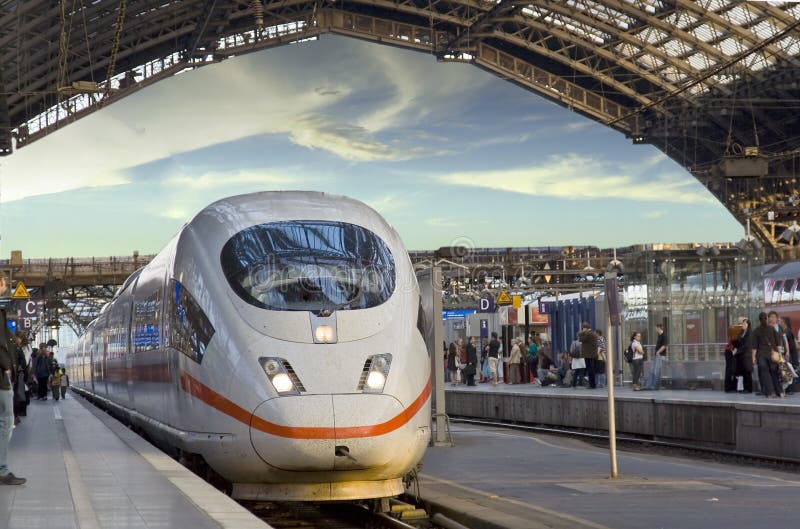 Train arrives platform on railroad station steel roof passengers crowd. Train arrives platform on railroad station steel roof passengers crowd