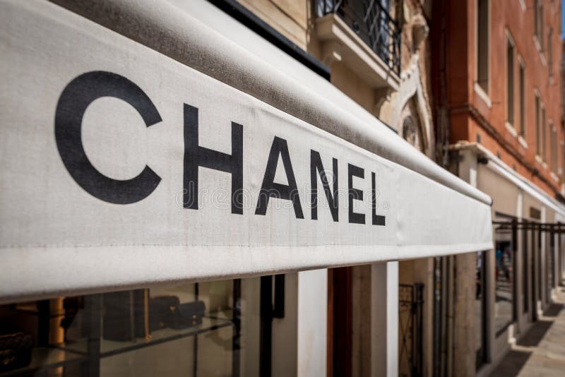 Veneza, Itália - 4 de julho de 2018: Chanel marca o sinal na parte dianteira da loja É uma casa de alta-costura que se especializ fotografia de stock Veneza, Itália - 4 de julho de 2018: Chanel marca o sinal na parte dianteira da loja É uma casa de alta-costura que se especializ fotografia de stock