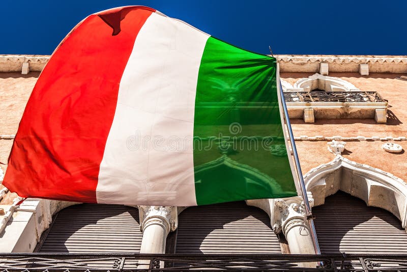 VENEZIA, ITALIA - 20 AGOSTO 2016: Bandiera e facciate italiane di vecchio primo piano medievale delle costruzioni il 20 agosto 20 fotografie stock VENEZIA, ITALIA - 20 AGOSTO 2016: Bandiera e facciate italiane di vecchio primo piano medievale delle costruzioni il 20 agosto 20 fotografie stock