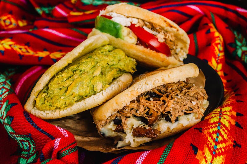 https://thumbs.dreamstime.com/b/venezuelan-arepas-colorful-background-made-maize-filled-avocado-tomato-meat-cheese-black-beans-close-up-dish-160211577.jpg