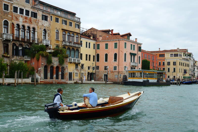 VENICE - AUGUST 25. Two Men On A Motor Boat Floating On ...