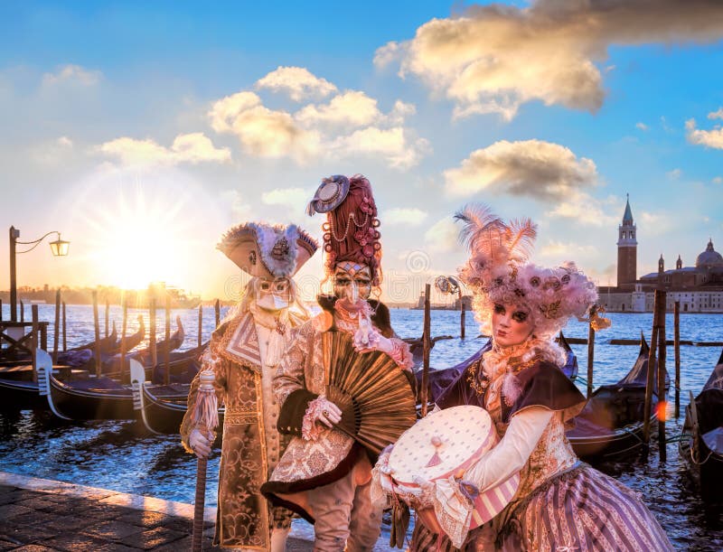 Famous Venice with carnival masks against colorful sunrise in Italy