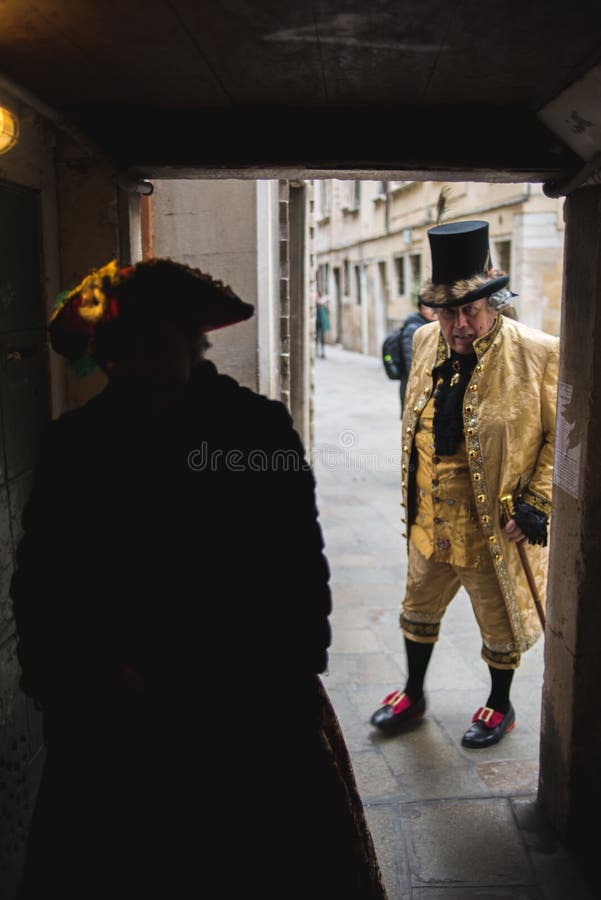 Venice, Italy - March 1, 2019: People dressed as Venetian carnival walking through the streets of Venice